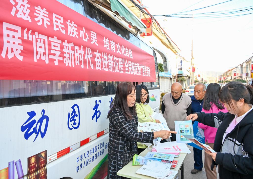 2023年10月24日,山西省左权县图书馆和左权县科学技术协会的工作人员在左权县寒王村向村民发放杂志和科普宣传单。新华社记者 杨晨光 摄