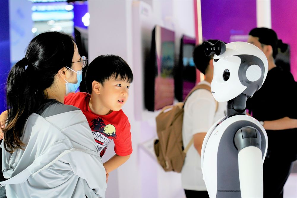 2023年7月6日,2023世界人工智能大会在上海世博中心拉开帷幕,这是参观者在达闼展位与柔美人形智能服务机器人互动。新华社发(李心怡 摄)